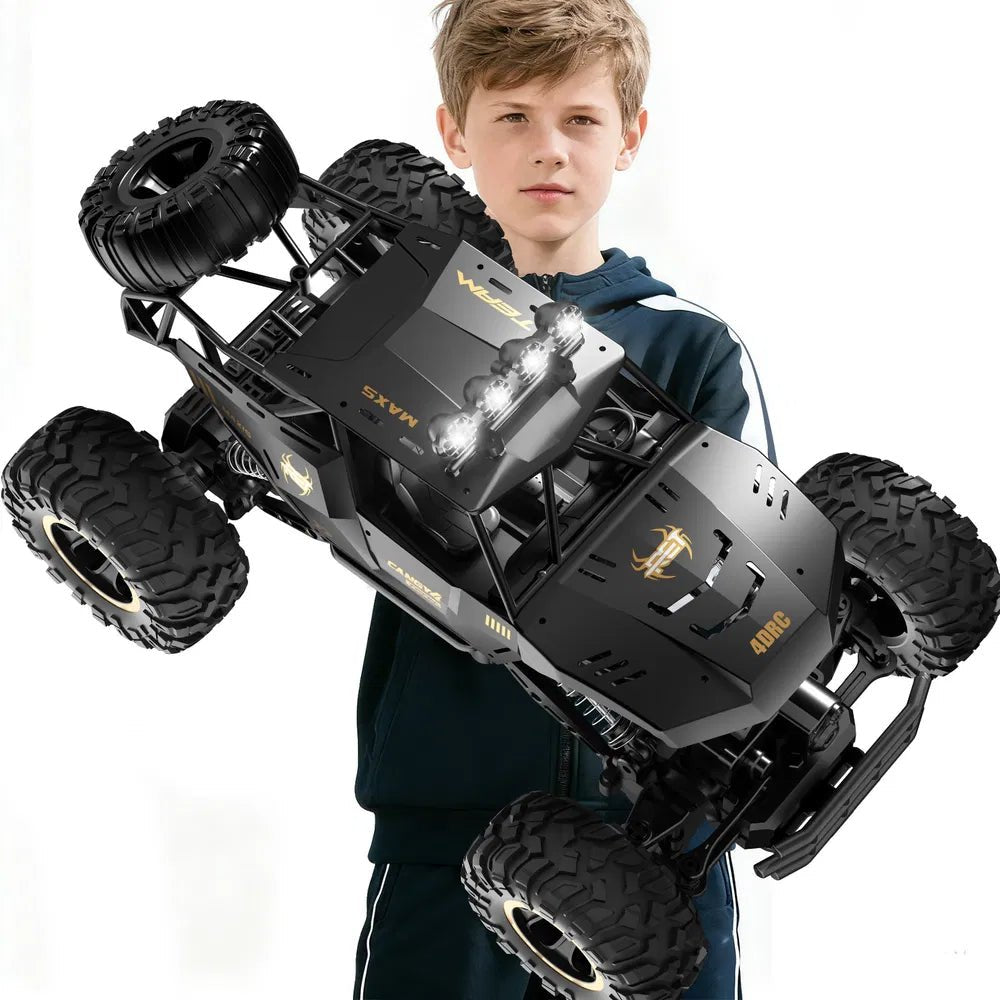 Boy holding large black 1:12 scale 4WD RC monster truck rock crawler with LED headlights