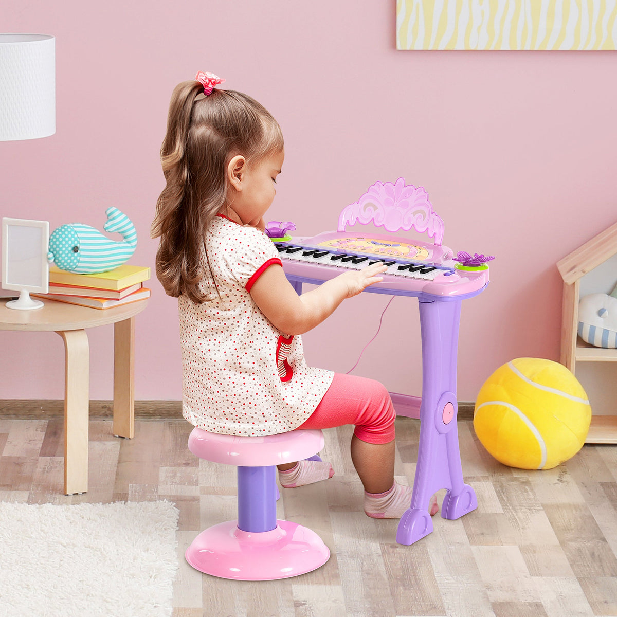 Child playing with pink 32-key kids electronic keyboard piano with microphone