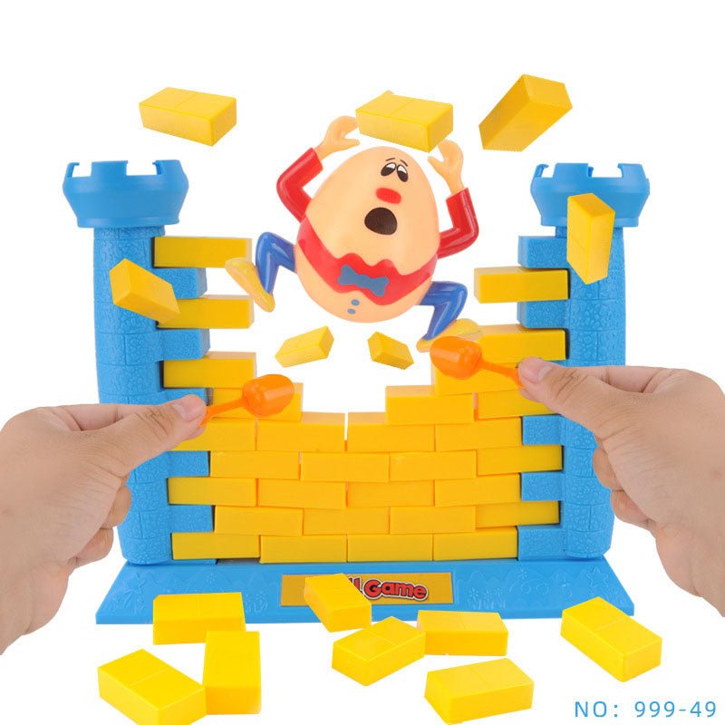 Two hands pushing bricks from Humpty Dumpty Wall Game causing Humpty figure to fall off blue castle