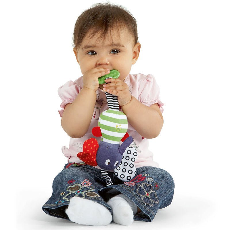 Toddler girl holding colorful soft musical elephant teether baby toy on white background